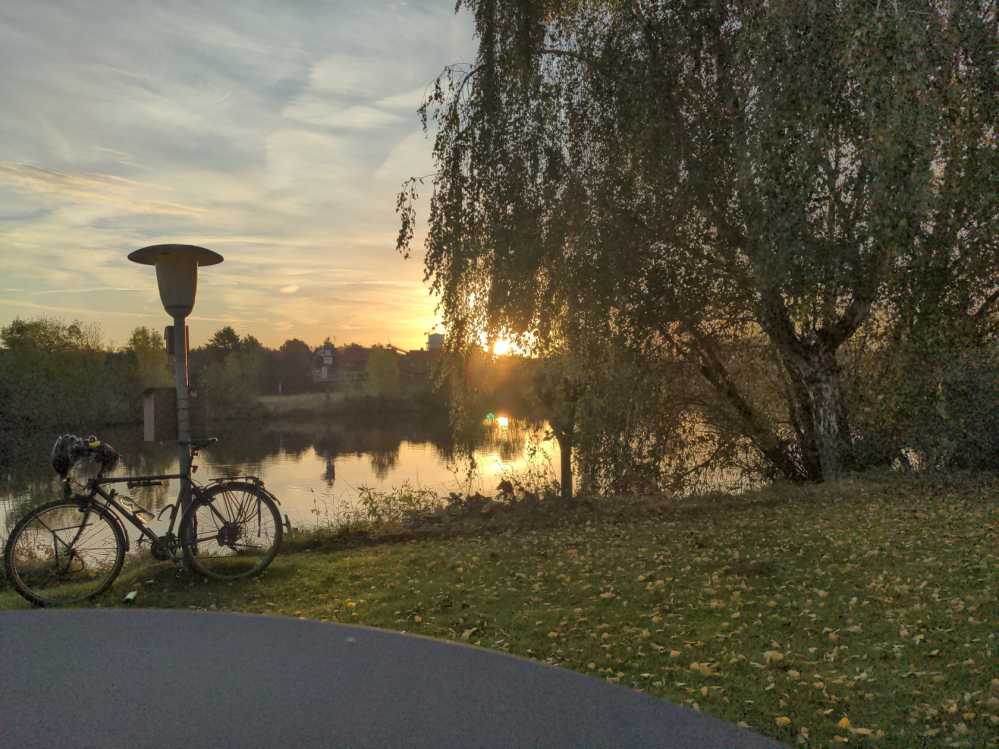 Weser Stolzenau Laterne Fahrrad Baum Weide Sonnenaufgang blauer Himmel Schmierwolken